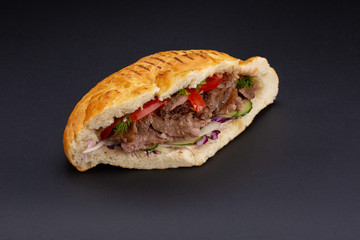 Kebab in pita bread on black background