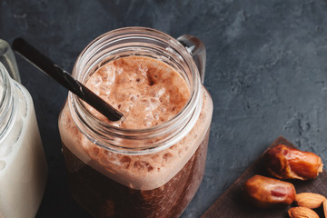 Chocolate smoothie in a jar with straw, protein milkshake, healthy eating, close-up view