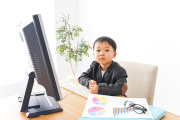 スーツを着て仕事をする子供ビジネスマン