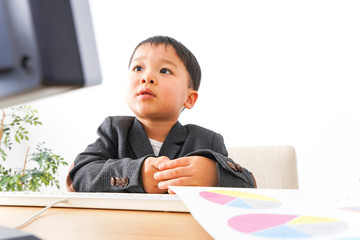 スーツを着て仕事をする子供ビジネスマン