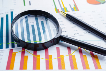 Magnifying glass on charts graphs spreadsheet paper. Financial development, Banking Account, Statistics, Investment Analytic research data economy, Stock exchange trading, Business office company meet