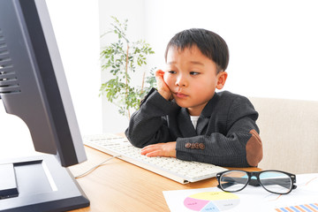 スーツを着て仕事をする子供ビジネスマン