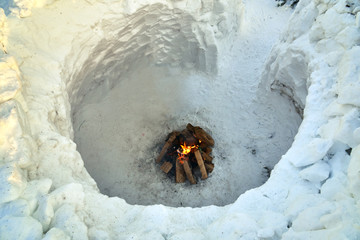 Interior of a igloo round snow house with a bonfire inside