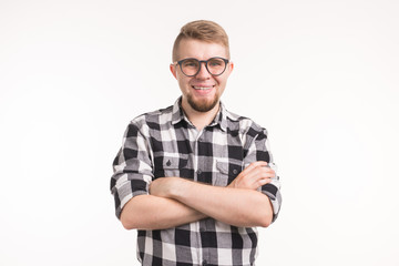 People, nerd and education concept - Smiling handsome student man in plaid shirt, crossed arms, over white background