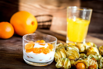 yogurt with physalis on wooden background