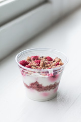 Healthy dessert with raspberries in plastic cup