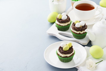 Easter chocolate cupcakes with nest and candy eggs for dessert.