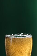 selective focus of beer glass isolated on green with copy space, st patrick day concept