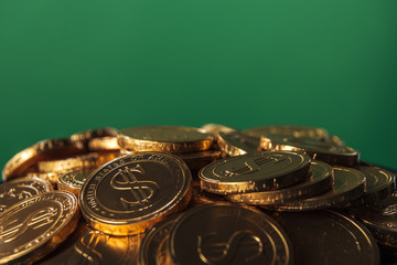 close up of golden coins isolated on green with copy space, st patrick day concept