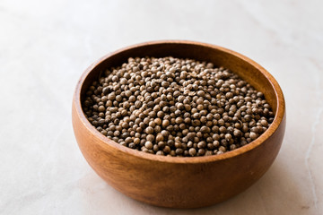 Organic Dried Coriander Seeds in Wooden Bowl.