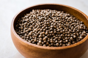 Organic Dried Coriander Seeds in Wooden Bowl.