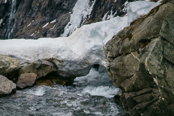 Spring in the mountains, snow melting with river flow.
