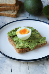 Toast with avocado and egg, bread slice with avocado and egg