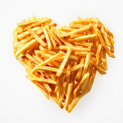 Close-up of salty French fries in heart shape