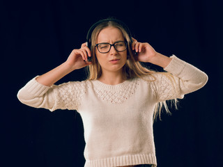 beautiful cheerful girl in headphones on black background.