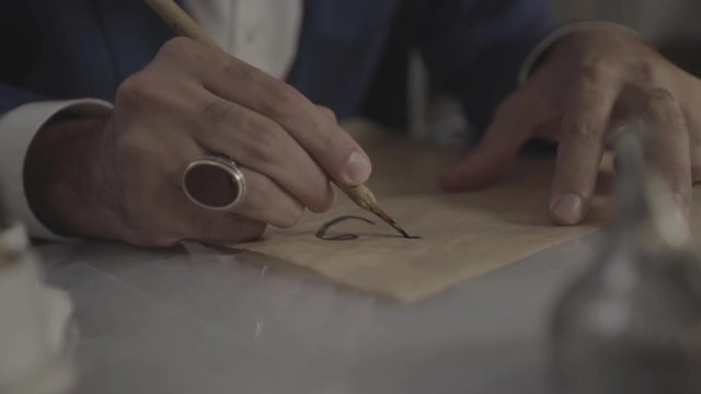 Male hand writing Alif Arabic character