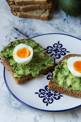 Toast with avocado and egg, bread slice with avocado and egg