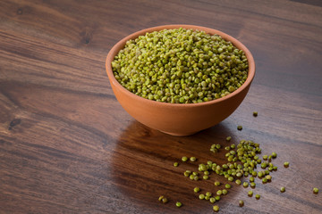 Front  View of Fresh Green Tender Sorghum in a Earthen Bowl on Wooden Background