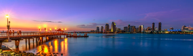Fototapeten Panorama of Coronado old pier reflecting on in San Diego Bay from Coronado Island, California, USA. San Diego cityscape skyline with Downtown and Waterfront Marina District at twilight on background. © bennymarty