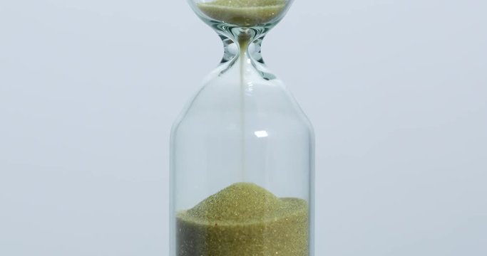 Sand falls quickly through an hourglass.