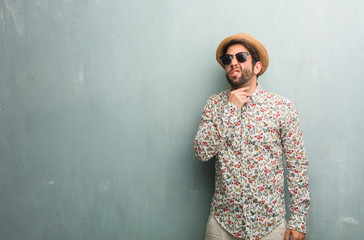 Young traveler man wearing a colorful shirt with a sore throat, sick due to a virus, tired and...