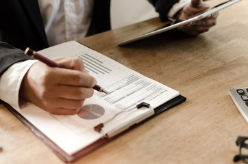 professional investor or business man analysis and calculating on financial reports and using mobile tablet on desk in office, investment, financial adviser, business working and savings money concept
