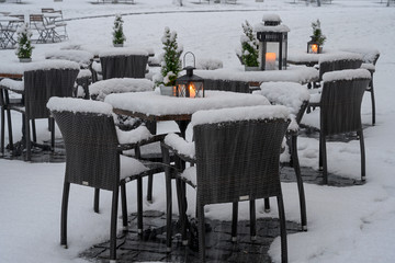 Schneebedeckte Tische u Stühle eines Restaurants am Mühleplatz, Luzern, Schweiz