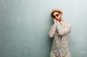 Young traveler man wearing a colorful shirt tired and very sleepy, looking comfortable and relaxed, sleep gesture