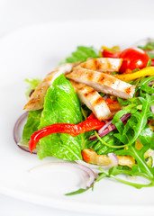Delicious salad with meat, tomatoes and greenery on white