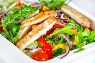 Delicious salad with meat, tomatoes and greenery on white