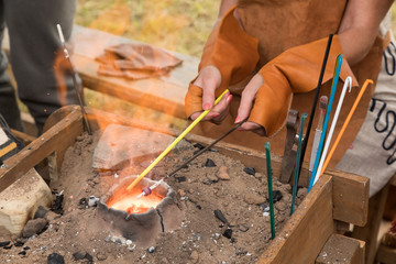 Glass blower's hands. To blow glass beads by means of fire.