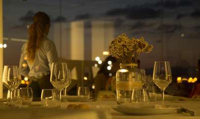 Elegant seaside restaurant outdoor dining table setup with ocean view, fine tableware, romantic ambiance, perfect for luxury vacation, summer dinner, or gourmet experience at sunset and night