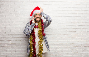 Young man sitting with gifts celebrating christmas forgetful, realize something