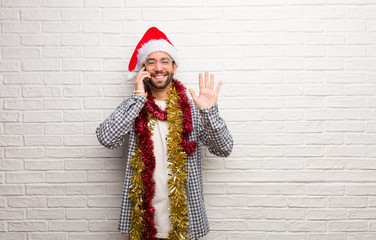 Young man sitting with gifts celebrating christmas showing number five