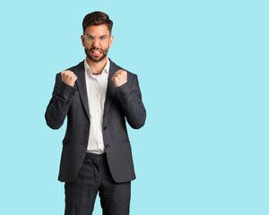 Young handsome business man screaming very angry and aggressive
