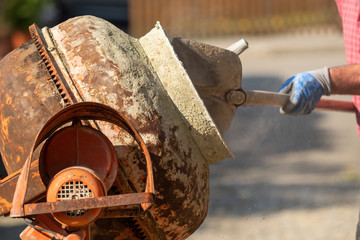 Construction site work with concrete mixer and wheelbarrows