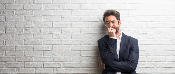 Young friendly business man biting nails, nervous and very anxious and scared for the future, feels panic and stress