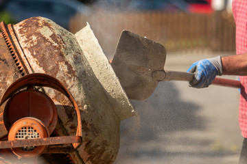 Construction site work with concrete mixer and wheelbarrows