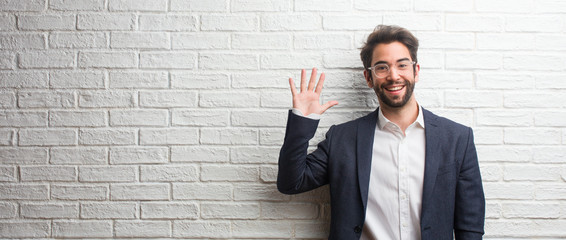 Young friendly business man showing number five, symbol of counting, concept of mathematics, confident and cheerful