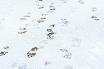 The first snow on the street. Traces on the snowy pavement. Winter weather background