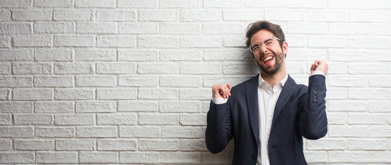 Young friendly business man listening to music, dancing and having fun, moving, shouting and expressing happiness, freedom concept