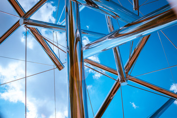 Looking up at the sky through a chrome statue