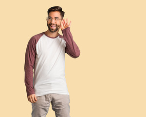 Fototapeta premium Young handsome man try to listening a gossip
