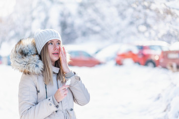 Lady hydrating her face skin with moisturizer cream in a snowy mountain in winter