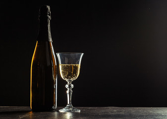 bottle of champagne and glasses over dark background