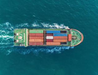Aerial top view small container ship delivering for logistic, import export, shipping or transportation.