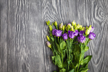 beautiful bouquet from purple eustoma flowers on dark wooden bac