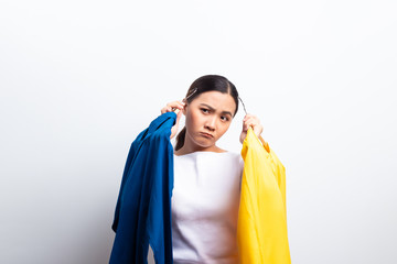 Woman feel confuse to choosing blouse isolated over white background