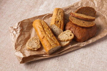 Naklejka premium bread ciabatta slices food background brown paper canvas wheat bran graine yeast leaven