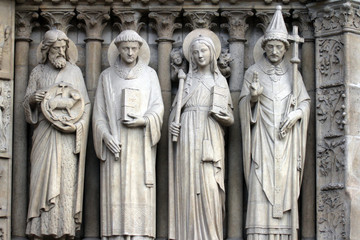 Fototapeta na wymiar Paris, Notre-Dame cathedral, portal of the Virgin, from left to right: Saint John the Baptist, Saint Stephen, Saint Genevieve and Pope Saint Sylvester.